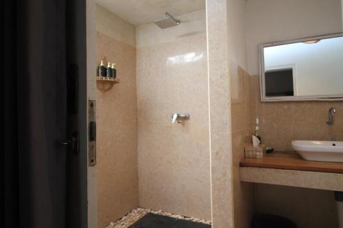 a bathroom with a shower and a sink at New Balengku Dua Hotel - Adults Only in Gili Islands