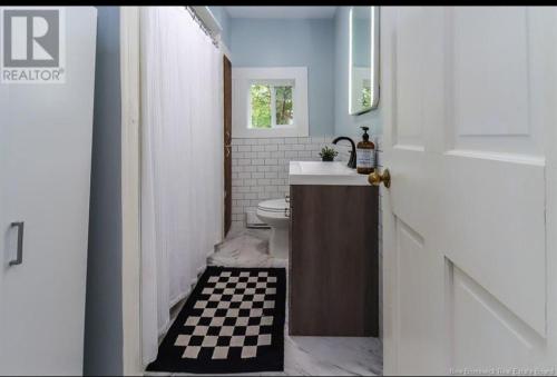 a bathroom with a sink and a toilet in it at Central, Dog Friendly, Parking in Saint John