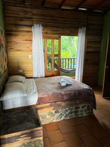 a large bed in a room with a window at Hotel El Santuario in Minca