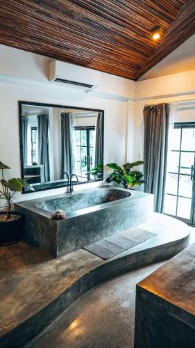 a large bath tub in a room with windows at Bliss Villa By Happiness Philippines in El Nido