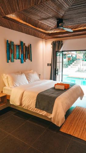 a bedroom with a large bed and a pool at Bliss Villa By Happiness Philippines in El Nido