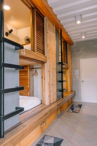 a bedroom with a bed in a room with wooden walls at Happiness Hostel Siargao in General Luna