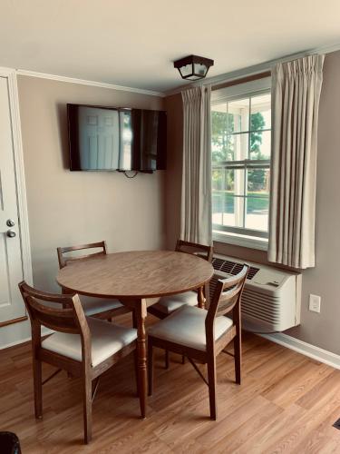 a dining room with a table and chairs and a window at The Chatham Motel in Chatham