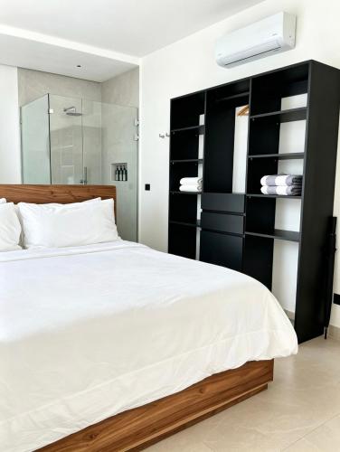 a bedroom with a bed and a black book shelf at NOAM by the sea in Tamarindo