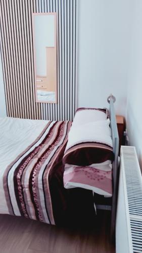 a bedroom with a bed with a striped wall at AAA lodge in Middlesbrough