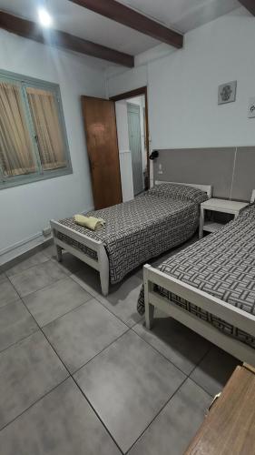 a room with two beds and a door and windows at TRINIDAD in San Juan