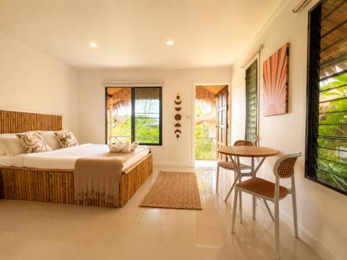 a bedroom with a bed and a table and chairs at Phangan Chalet Bungalows in Chaloklum