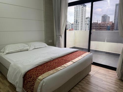 a bedroom with a large bed and a large window at Skyline hotel in Phnom Penh