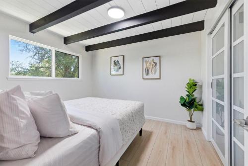a white bedroom with a bed and a window at Remodeled Yosemite Cabin Sleeps 12 in Groveland