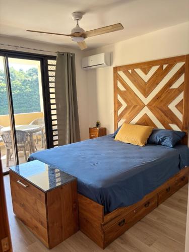 a bedroom with a large bed with a wooden headboard at Zen escape-ocean view Papeete in Papeete