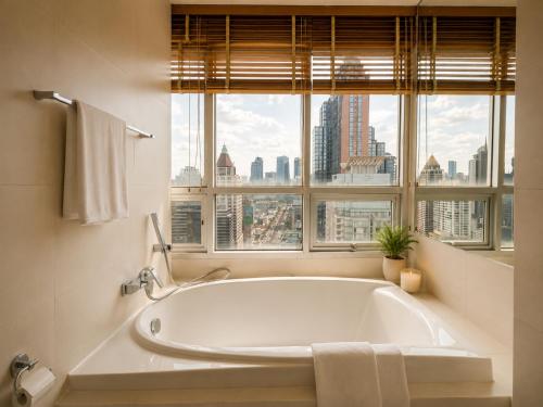 a bath tub in a bathroom with a window at Urbana Sathorn Hotel, Bangkok in Bangkok