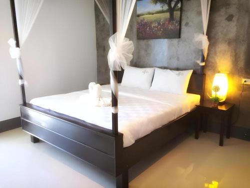 a bedroom with a bed with white comforter and flowers on it at The Key Hotel in Ko Lipe