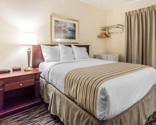 a hotel room with a large bed and a table at Econo Lodge in Temiskaming Shores