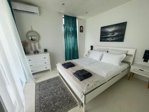 a white bedroom with a bed with white sheets and a mirror at Krum's Little Secret Villa in Vourvourou