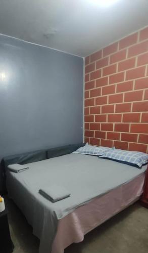 a bed in a room with a brick wall at Renta Rey David in Caracas