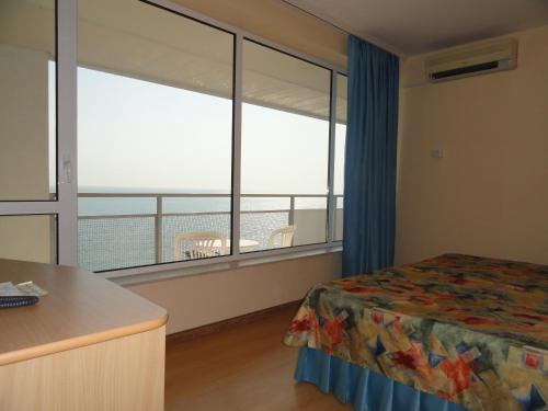 a bedroom with a bed and a large window at Bonita Hotel in Golden Sands