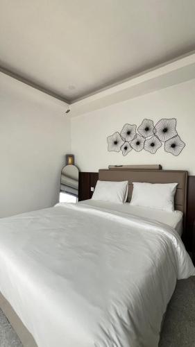 a bedroom with a large white bed with white pillows at Papayas 2 Villa in Yogyakarta