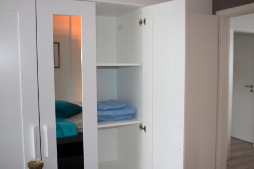 a closet with white cabinets and a bed at Gästewohnung Mönchengladbach in Mönchengladbach