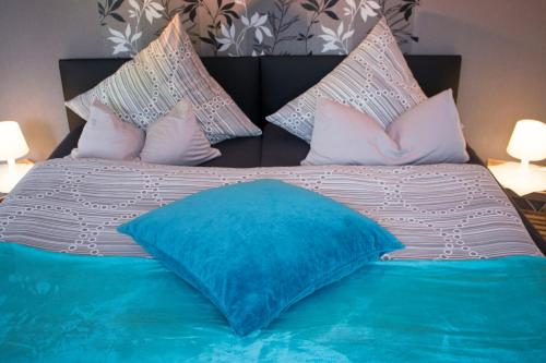 a large bed with a blue pillow on it at Gästewohnung Mönchengladbach in Mönchengladbach