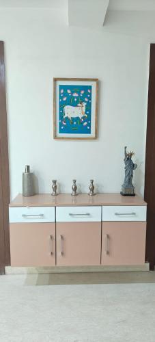 a dresser with a painting on the wall and a picture at Bell Rooms Hotel in Noida