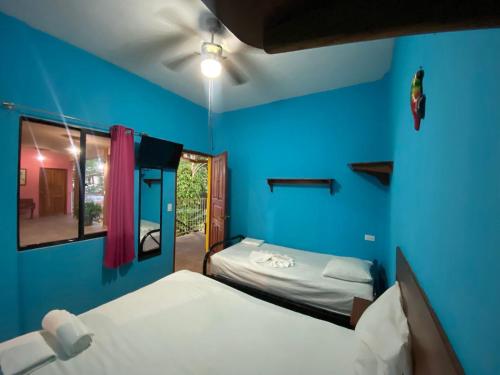 a room with two beds and a blue wall at Hotel del Sur in San Juan del Sur