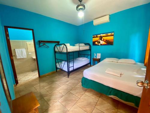 a blue room with a bed and a mirror at Hotel del Sur in San Juan del Sur