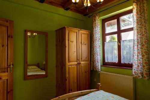 ボニャルツバシュにあるBlasius Apartmanの緑の壁のベッドルーム1室(窓、ベッド1台付)