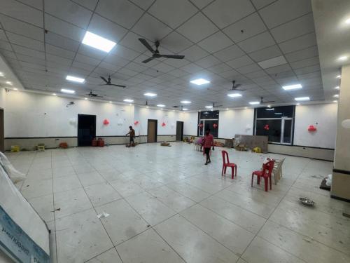 a large room with a dance floor with red chairs at Hotel Brijraj Dham in Govardhan