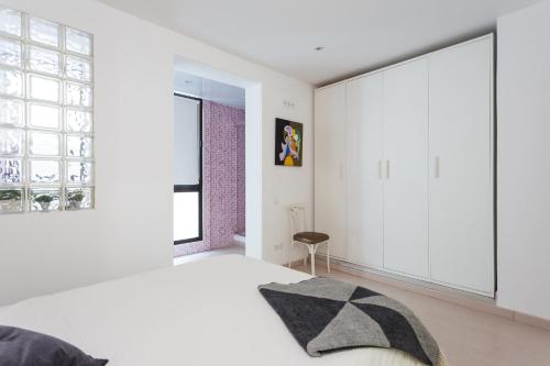 バルセロナにあるCasa Cosi Letamendiの白いベッドルーム(大きな窓、ベッド付)