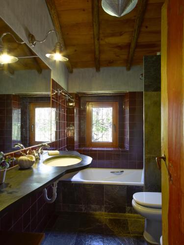 a bathroom with a tub and a sink and a toilet at Casas da Estação, Country Houses in Marvão