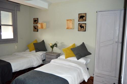 two beds in a room with yellow and white at The Hostel in Sierra Nevada