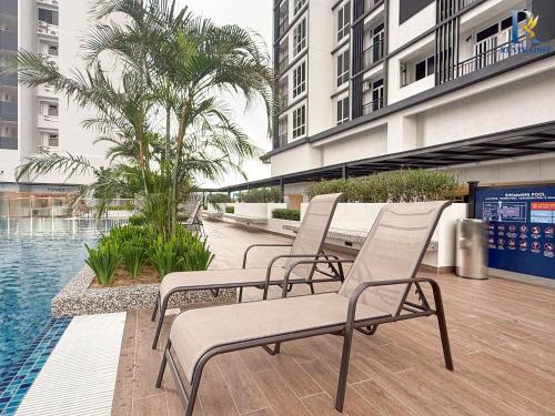 a group of chairs sitting next to a swimming pool at Trellis Residence by RR JBcity in Johor Bahru