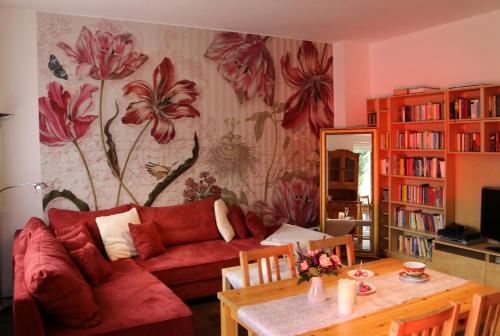 a living room with a red couch and a table at Gästewohnung Mönchengladbach in Mönchengladbach