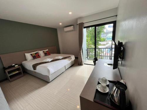 a bedroom with a bed and a large window at Baan Nan B&B Hotel in Nan
