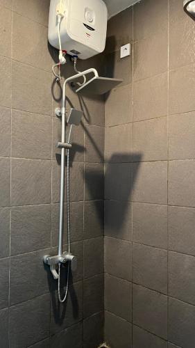 a shower in a bathroom with a hair dryer at Papayas 2 Villa in Yogyakarta