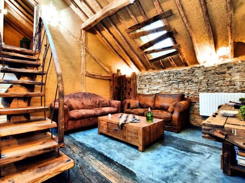 een woonkamer met een bank en een tafel bij Beautiful one of its kind home with a sauna in Oppagne