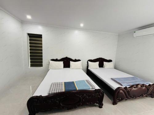 two beds in a small room with two bedsitures at Khách sạn AMI in Vinh