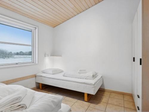 a white room with two beds and a window at Apartment With Golf Course Right Outside in Pandrup