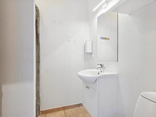 a white bathroom with a sink and a shower at Apartment With Golf Course Right Outside in Pandrup