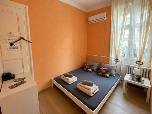 a small room with a bed with pillows and a window at Habitat Hostel in Belgrade