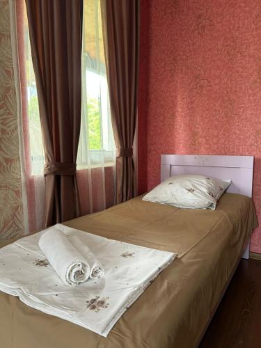 a bed in a room with a window and a bedspread at LeriMari in Mestia