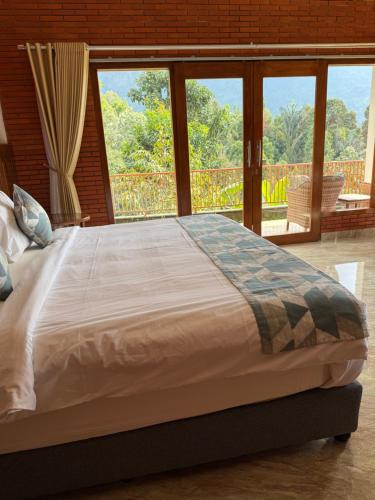a bed in a room with a large window at The Mungseng Villa Bali in Singaraja