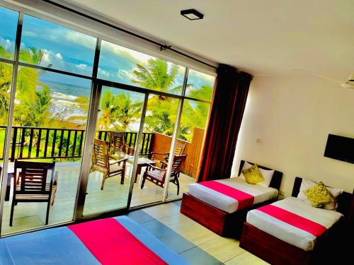a room with two beds and a view of the ocean at Villa Ocean Dew in Galle
