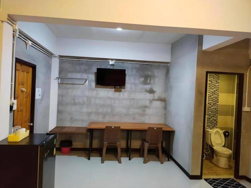 a dining room with a table and a toilet at Kidthuengpark in Ban Nong Faep