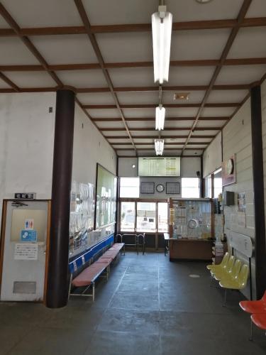 a room with benches and tables in a building at 駅舎泊ラッセルイン in Hirakawa