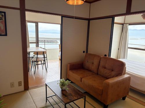 a living room with a couch and a bed and a table at 指宿 潮音 Ibusuki Shione in Ibusuki