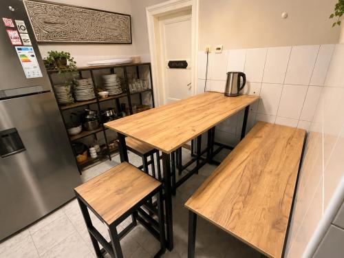 a kitchen with two wooden tables and a refrigerator at Habitat Hostel in Belgrade