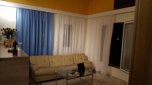 a living room with a couch and a glass table at Varmy in Ierápetra