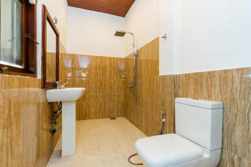 a bathroom with a toilet and a sink at Lucas Hotel in Kosgoda