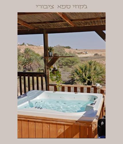 a hot tub on a deck with a view of the desert at DESERT Ezuz in ‘Ezuz